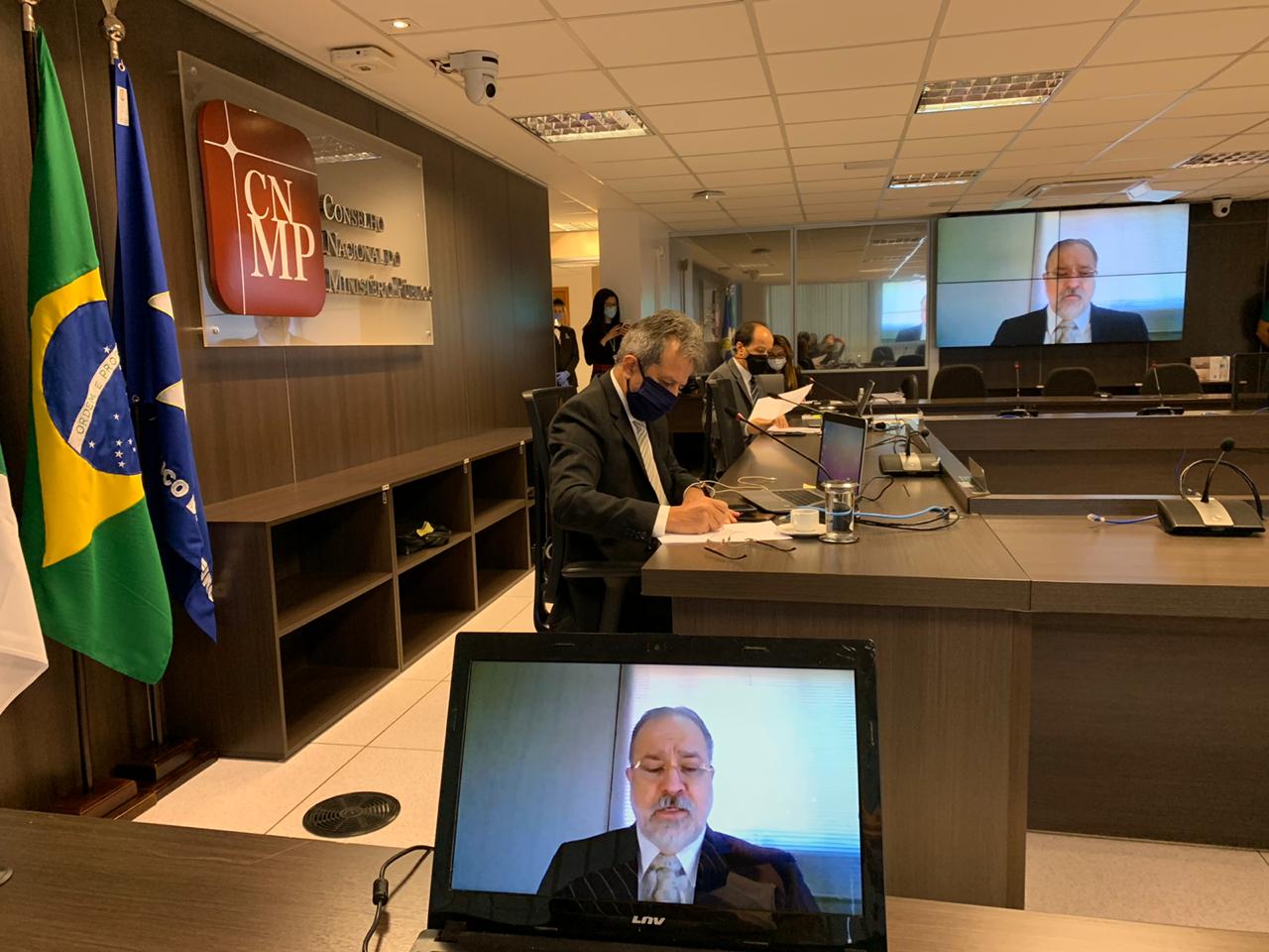 Plenário do CNMP com Augusto Aras em um monitor